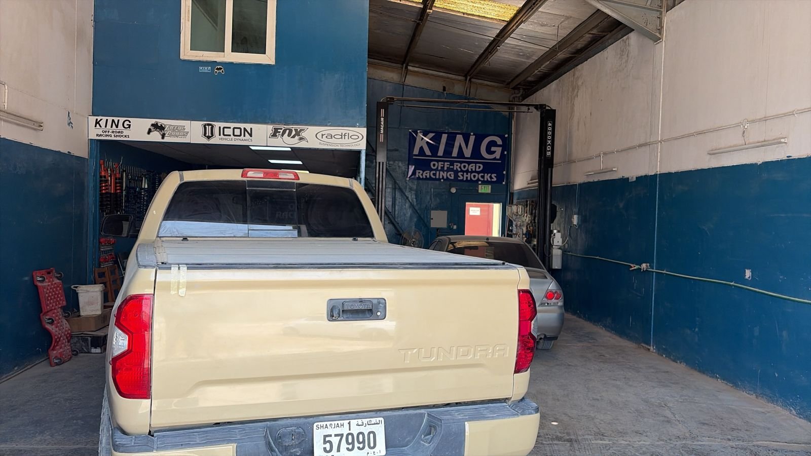 Inside the Al Madinah Al Yash workshop with vehicles and the King, Icon, Fox and Radflo brand wall